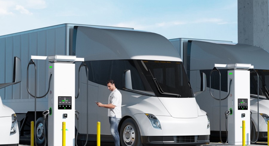 Electric semi trucks charging at Autel MaxiCharger DC HiPower dispensers with driver checking phone